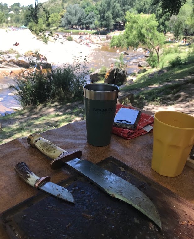 MC Knifemaker knives outdoors beside a river