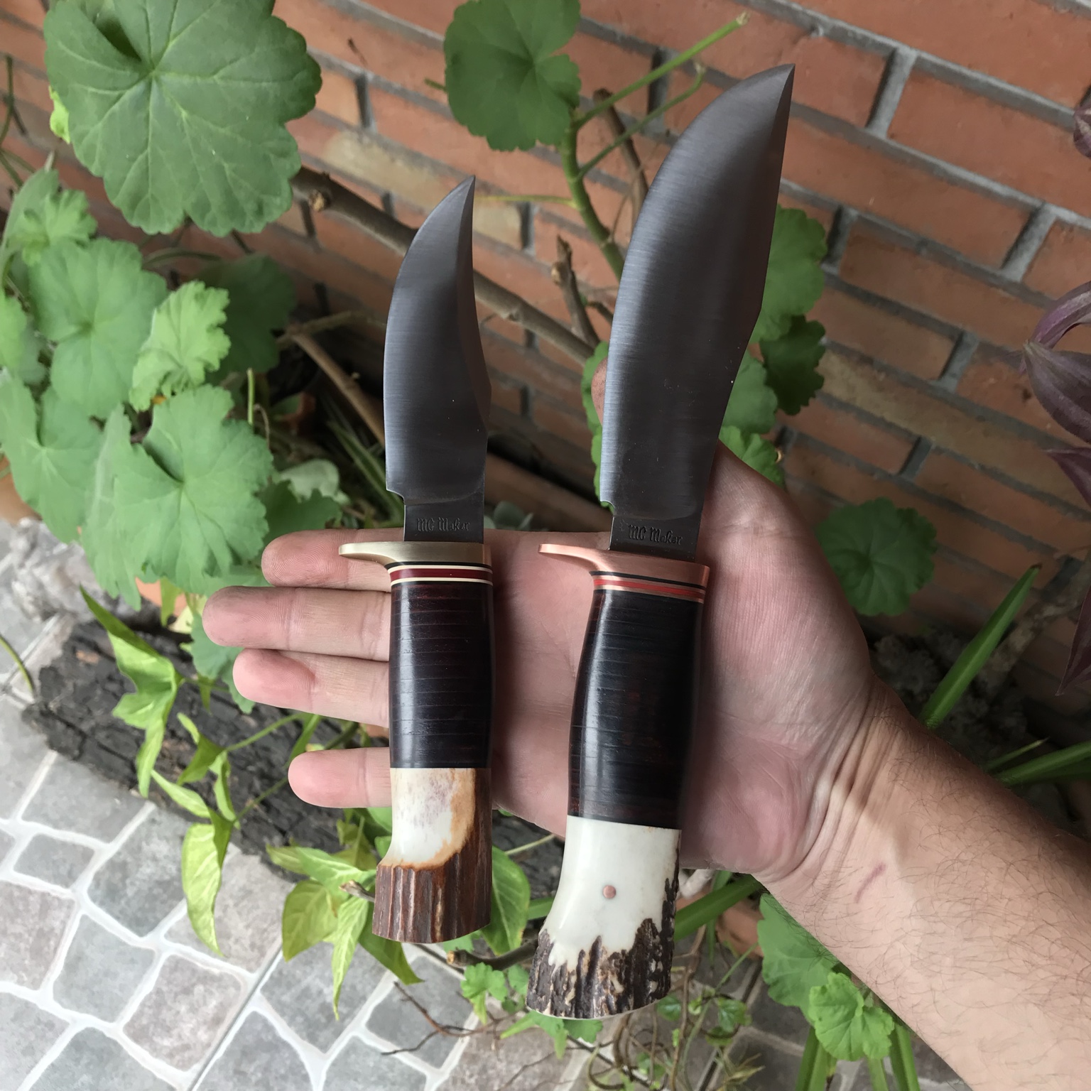 Two handmade knives held in hand